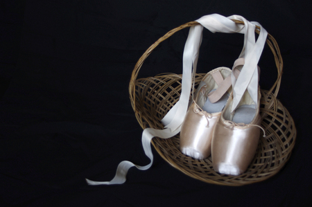 new pink ballet Pointe shoes in wood basket with copy spaceの写真素材