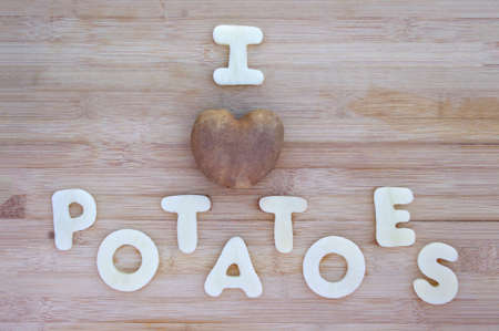 I love potatoes words with heart shaped potato on wood backgroundの写真素材