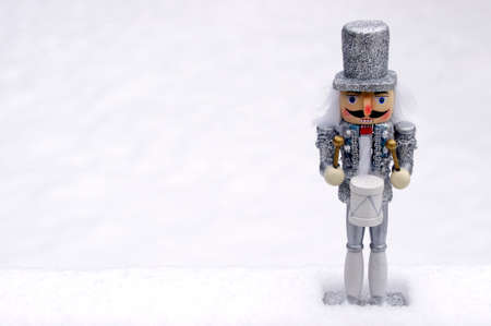 silver toy nutcracker in white snow with copy spaceの写真素材