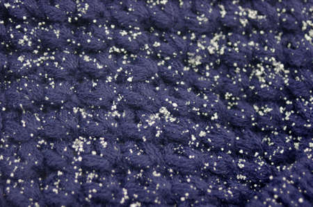 close up of blue knit hat with white snowflakes