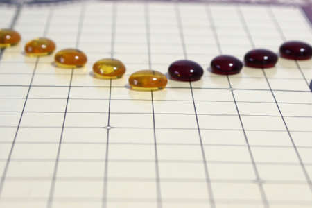yellow and red glass beads on game board gridの写真素材
