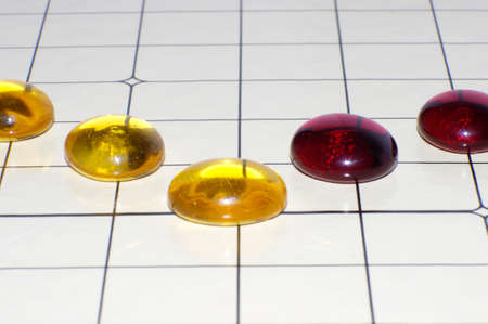 yellow and red glass beads on game board grid