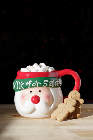 funny Santa Clause face coffee mug with hot chocolate, marshmallows, gingerbread cookie on wooden table with copy spaceの写真素材