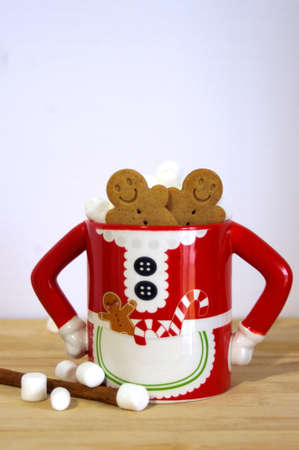 funny Mrs. Santa Clause coffee mug with hot chocolate, marshmallows, gingerbread cookies, cinnamon stick on wooden table with copy spaceの写真素材