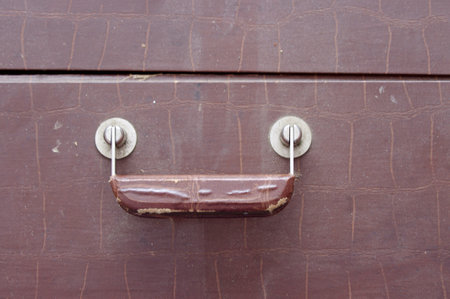 large vintage brown leather handle on a closed suitcaseの写真素材