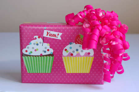 pink birthday cupcake wrapped box with bright pink bowの写真素材
