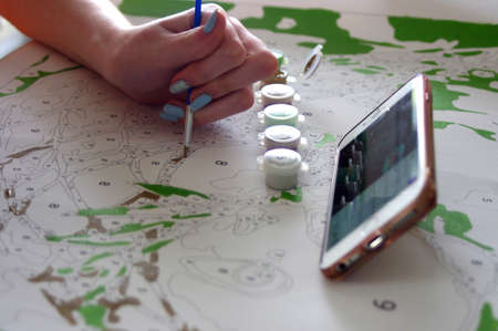 teenager painting pain by number with cell phoneの写真素材