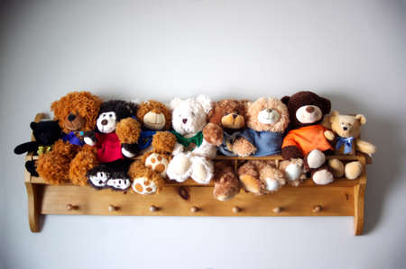 group of teddy bears sitting on wall shelfの写真素材