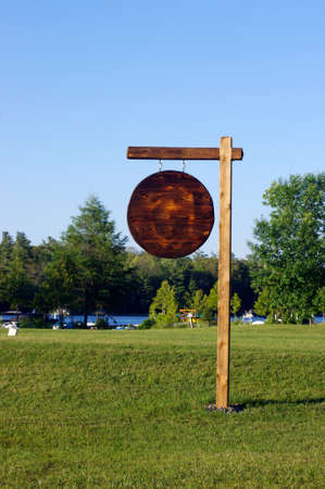 blank rustic wooden sign on green grass in summerの写真素材