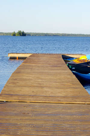 wooden dock on blue water with blue sky and copy spaceの写真素材