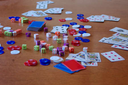 table full of cards, poker chips and diceの写真素材