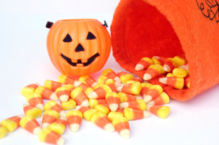 orange pumpkin bag with Halloween candy corn with mini Jack-o-lantern pumpkinの写真素材
