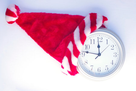 silver clock showing a quarter to 12 with Christmas Santa hat onの写真素材