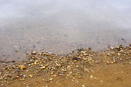 rocks on sandy beach texture in summer with copy spaceの写真素材