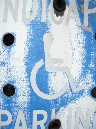 close up of a scratched and weatherworn handicap parking signの写真素材