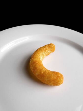 A bright orange cheese puff on a plate
