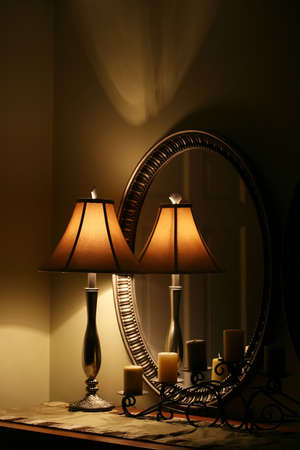 A cozy interior still life with lamp, candles and mirrorの写真素材