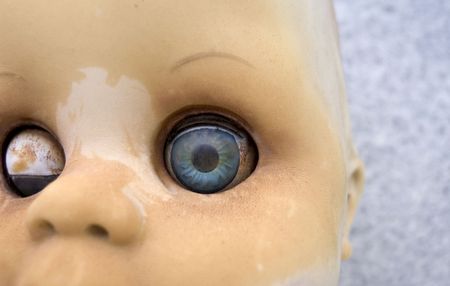 Close up of an an old worm doll with blue eyesの写真素材