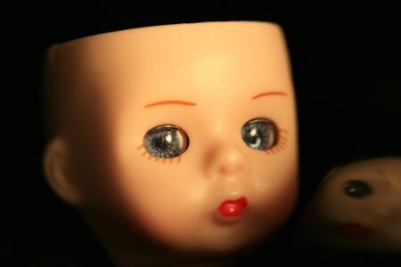 A close up of a doll's head with reflection in black backgroundの写真素材
