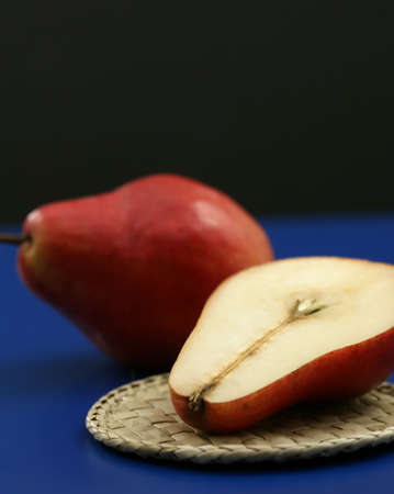 Fresh red organic pears with a blue and black backgroundの写真素材