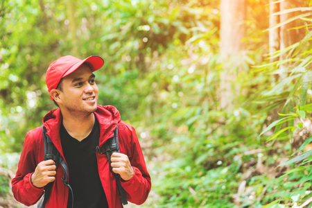 Young asian travel handsome man hiking in forest and mountain enjoy walking in nature outdoors. Image of lifestyle camping,travel,hiking or recreation concept with copy space.の写真素材