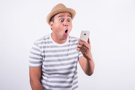 Young asian man shocked when he looking smartphoneの写真素材