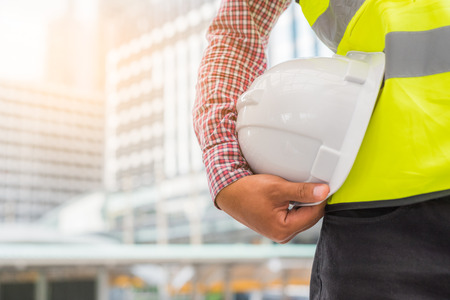 Engineering holding safety helmet on building background.の写真素材