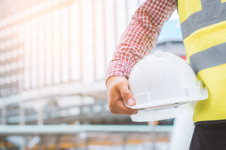 Engineering holding safety helmet on building background.の写真素材