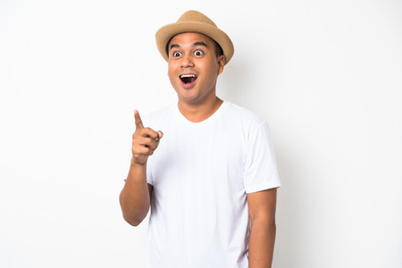 Young asian man with hat feels shock and surprise with overly face expression and looking on blank space.の写真素材