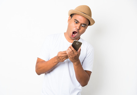 Surprised and shocked asian man looking smartphoneの写真素材