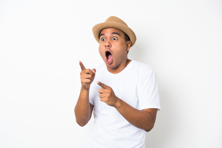 Young asian man with hat feels shock and surprise with overly face expression and looking on blank space.の写真素材