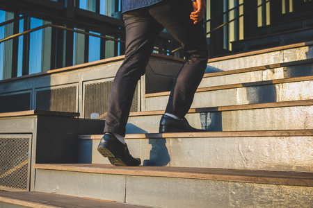 Businessman legs walking up the stairsの写真素材