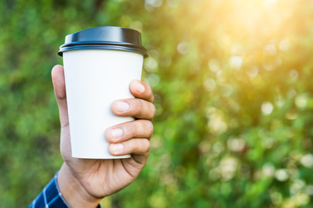 Close up hand man holding coffee paper cup.