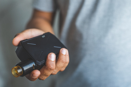 Young man holding electronic cigarette.