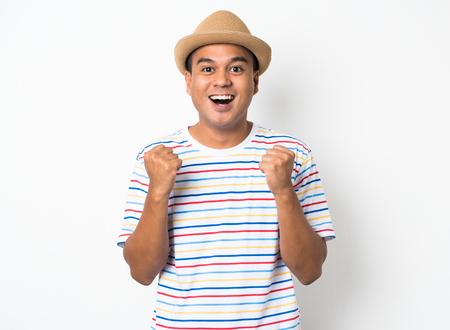 Happy young asian man celebrates with two hand in the air on isolate white background.の写真素材