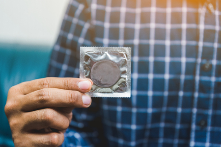 Male hand holding Condom. Safe sex concept.の写真素材