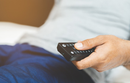 Hand man holding television remote.の写真素材