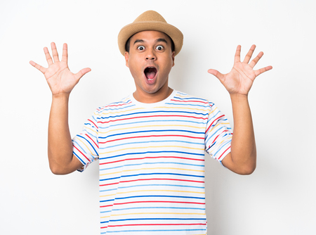 Young Asian man with hat feels shock and surprise with overly face expression.の写真素材