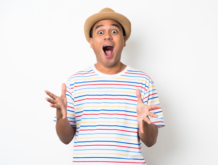 Young Asian man with hat feels shock and surprise with overly face expression.の写真素材