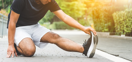 Young man runner stretching for warming up before running or working outの写真素材