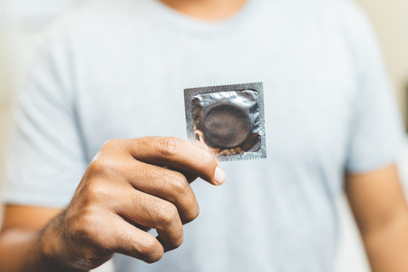 Male hand holding Condom. Safe sex concept.の写真素材