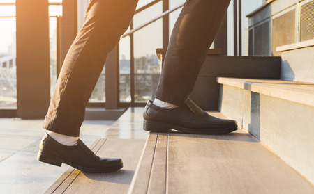 Businessman legs walking up the stairs
