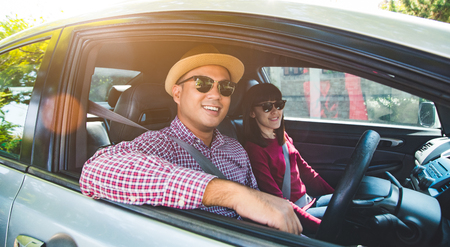 Front view of Funny moment couple asian man and woman sitting in car. Enjoying travel concept.の写真素材