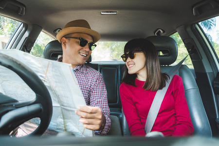 Couple asian man and woman sitting in car. Enjoying travel concept.の写真素材