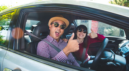 Happy moment couple asian man and woman sitting in car. Enjoying travel concept.の写真素材
