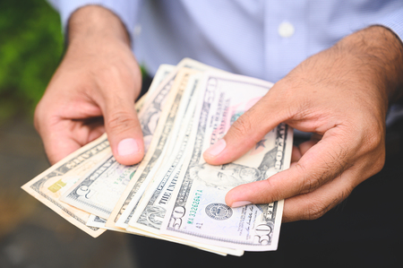 Close up people hand hold count the money spread of cash. Concept finance Saving money.の写真素材