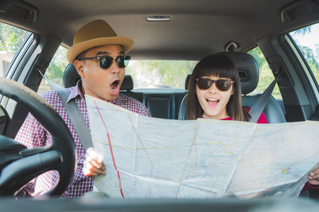 Young asian man and woman shocked when see the map while sitting in car.の写真素材