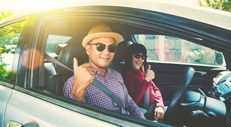 Happy moment couple asian man and woman sitting in car. Enjoying travel concept.の写真素材