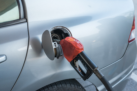 Pumping gasoline fuel in car at gas stationの写真素材