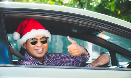 Young asian man showing thumb up while driving car.の写真素材